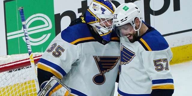 St. Louis Blues' David Perron, right, and St. Louis Blues goalie Ville Husso, celebrate after the Blues beat the Minnesota Wild 4-0 in Game 1 of an NHL hockey Stanley Cup first-round playoff series, Monday, May 2, 2022, in St. Paul, Minn. Perron scored three goals.