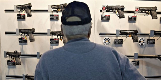 An attendee views Smith &amp; Wesson Corp. pistols at the company's booth during the National Rifle Association (NRA) annual meeting of members in Indianapolis, Indiana, U.S., on Saturday, April 27, 2019. 