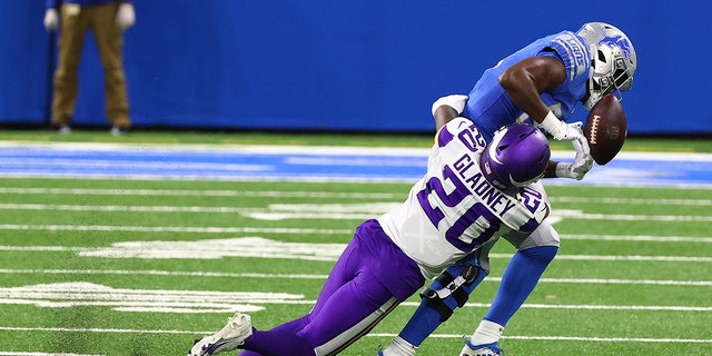 Kerryon Johnson #33 of the Detroit Lions attempts to make a catch in front of Jeff Gladney #20 of the Minnesota Vikings in the second quarter at Ford Field on January 3, 2021. 