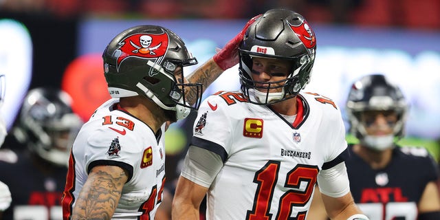 Tom Brady (12) of the Tampa Bay Buccaneers celebrates with Mike Evans (13) after a touchdown pass to Rob Gronkowski against the Atlanta Falcons at Mercedes-Benz Stadium Dec. 5, 2021, in Atlanta.