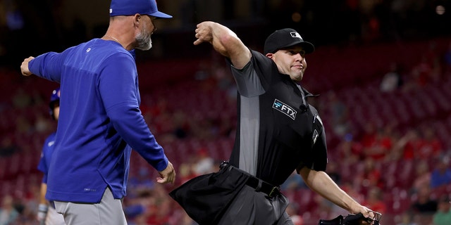 Umpire Dan Merzel ejects Chicago Cubs manager David Ross in the ninth inning of a game against the Cincinnati Reds at Great American Ball Park May 25, 2022, in Cincinnati. 