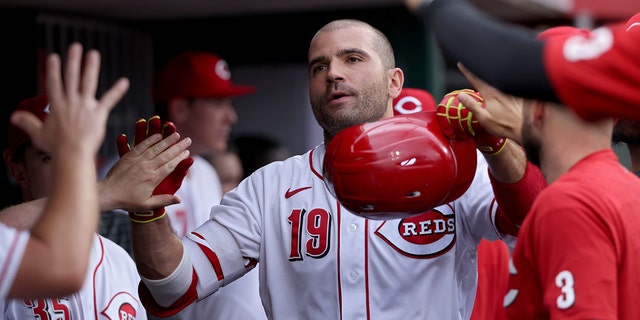 Joey Votto (19) of the Cincinnati Reds celebrates with teammates after hitting a home run in the second inning against the Chicago Cubs at Great American Ball Park May 25, 2022, in Cincinnati. 