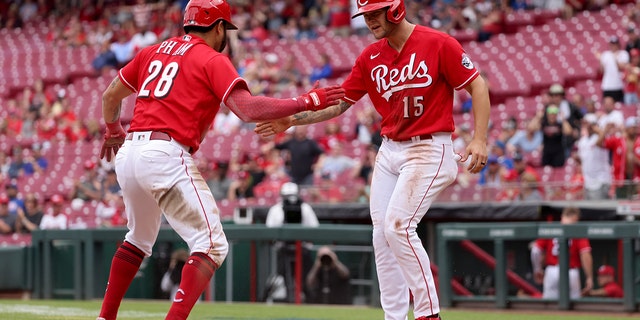 Tommy Pham and Nick Senzel of the Reds celebrate after scoring runs against the Chicago Cubs at Great American Ball Park on May 26, 2022, in Cincinnati, Ohio.