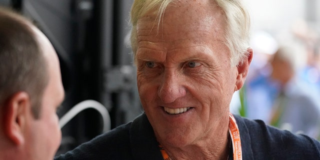 Professional golfer Greg Norman walks through the pit area during the third practice session for the Formula One Miami Grand Prix auto race at the Miami International Autodrome, Saturday, May 7, 2022, in Miami Gardens, Fla.