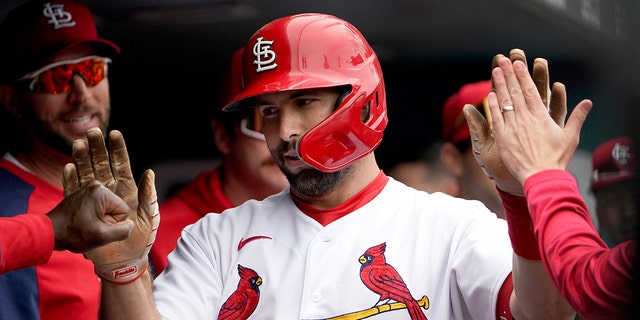 St. Louis Cardinals' Paul Goldschmidt is congratulated by teammates after hitting a solo home run during the first inning of a baseball game against the Kansas City Royals Monday, May 2, 2022, in St. Louis.
