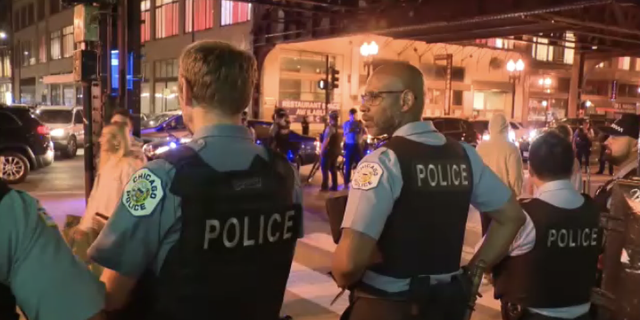 Police line the streets of downtown Chicago after a 16-year-old boy was shot and killed in Millennium Park Saturday night May 14, 2022.