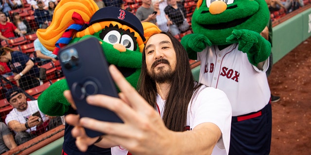 DJ Steve Aoki poses for a selfie with Red Sox mascots Tessie and Wally before throwing out a ceremonial first pitch on May 16, 2022 at Fenway Park.