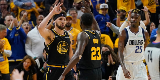 Golden State Warriors guard Klay Thompson (11) celebrates his basket with forward Draymond Green (23), next to Dallas Mavericks forward Reggie Bullock (25) during the first half in Game 5 of the NBA basketball playoffs Western Conference finals in San Francisco, Thursday, May 26, 2022. (AP Photo/Jeff Chiu)