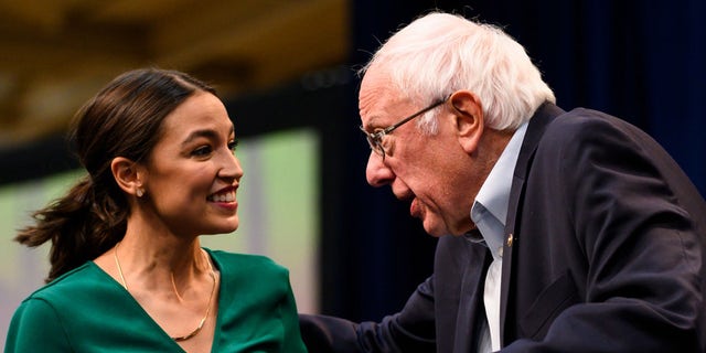 U.S. Rep. Alexandria Ocasio-Cortez (D-NY) is joined on stage by Democratic Presidential candidate Bernie Sanders (I-VT) during the Climate Crisis Summit at Drake University on November 9, 2019, in Des Moines, Iowa. 