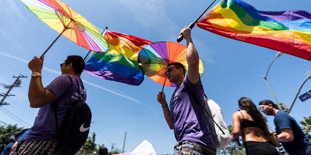 People participate at the inaugural WeHo Pride Parade in West Hollywood, Calif., on Sunday, June 5, 2022. The city of Aurora, Illinois revoked a permit for the pride event there after organizers failed to meet the required number of law enforcement officers for the event following controversy in which officers were told they could not dress in uniform. 
