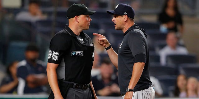 New York Yankees manager Aaron Boone (17) has words with home plate umpire Stu Scheurwater (85) after being thrown out of the game in the eighth inning against the Oakland Athletics, Tuesday, June 28, 2022, in New York. 