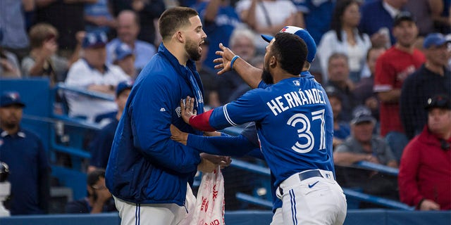 Toronto Blue Jays pitcher Alek Manoah, left, is held back by outfielder Teoscar Hernandez during a heated exchange with the Boston Red Sox after Blue Jays' Alejandro Kirk was hit by a pitch during the fourth inning of a baseball game Wednesday, June 29, 2022, in Toronto. 