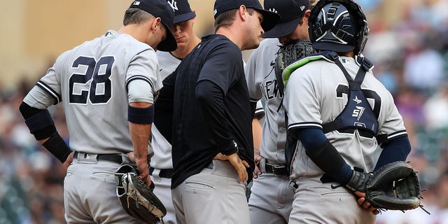 Matt Blake of the New York Yankees talks to Gerrit Cole and the rest of the infield after Cole gave up three solo home runs in a row against the Twins at Target Field on June 9, 2022, in Minneapolis, Minnesota.
