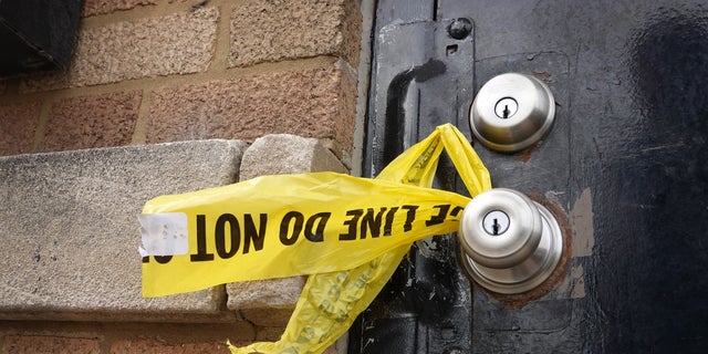 CHICAGO, ILLINOIS - MARCH 14: Crime scene tape hangs from a door knob outside of a tow company garage following a shooting where at least 15 people were reported to have been shot, two fatally, on March 14, 2021 in Chicago, Illinois. 