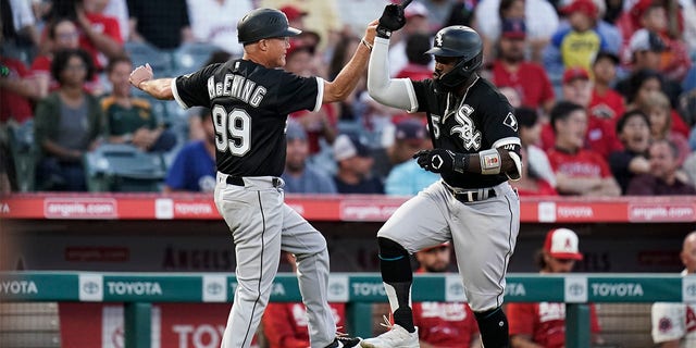 Chicago White Sox's Josh Harrison, right, celebrates his two-run home run against the Los Angeles Angels with third base coach Joe McEwing during the fifth inning of a baseball game Tuesday, June 28, 2022, in Anaheim, Calif. 