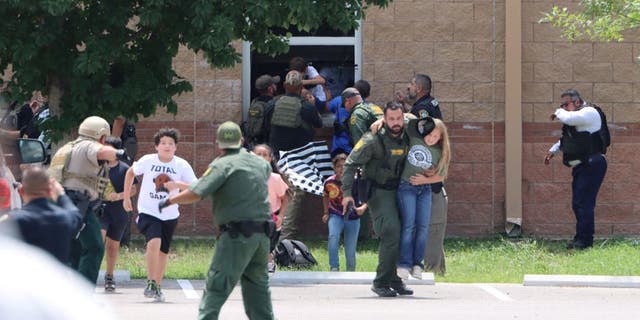 Children run to safety after escaping from a window during a mass shooting at Robb Elementary School, where a gunman killed 19 children and two adults in Uvalde, Texas, May 24, 2022. 