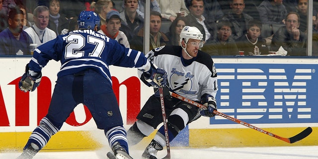 Brad Richards (19) of the Tampa Bay Lightning carries the puck as Bryan Marchment (27) of the Toronto Maple Leafs lines him up for a check March 23, 2004, at Air Canada Centre in Toronto, Ontario, Canada.
