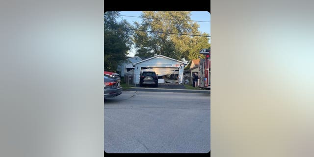 The SUV first slammed into a detached garage and then continued on into the house where it became stuck. The garage appeared to have partially collapsed. (Danielle Leschuk)