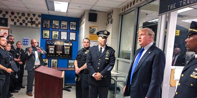 Former President Trump, second from right, commemorated the 20th anniversary of the Sept. 11 attacks by visiting the NYPD's 17th police precinct in New York, on Saturday Sept. 11, 2021. (AP Photo/Jill Colvin)