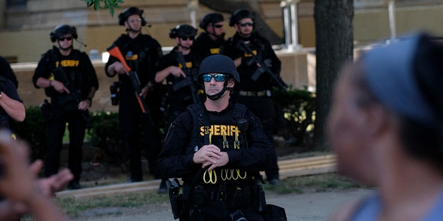 Members of the Sheriff department in riot gear stand by as demonstrators gather outside Akron City Hall to protest the killing of Jayland Walker, shot by police, in Akron, Ohio, July 3, 2022.
