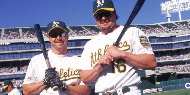Brothers Jason Giambi (#16) and Jeremy Giambi of the Oakland A's pose together before a game at Network Associates Coliseum in Oakland, California.