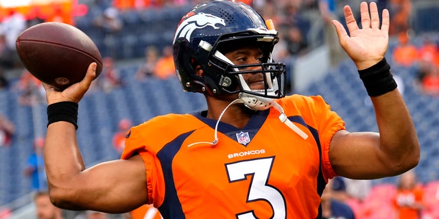 Denver Broncos quarterback Russell Wilson, above, warms up before an NFL preseason football game against the Dallas Cowboys.