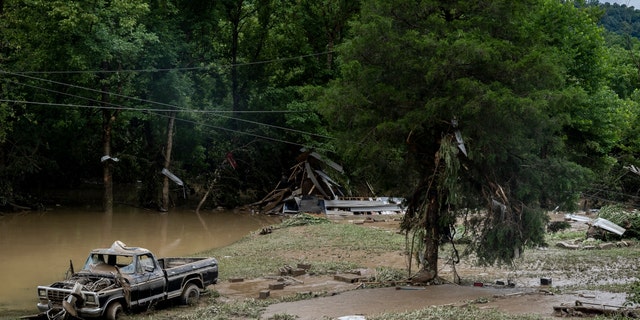 A damaged vehicle and debris are seen along the Bert T Combs Mountain Highway on July 29, 2022, near Hazard, Kentucky. At least 16 people have been killed and hundreds had to be rescued amid flooding from heavy rainfall.