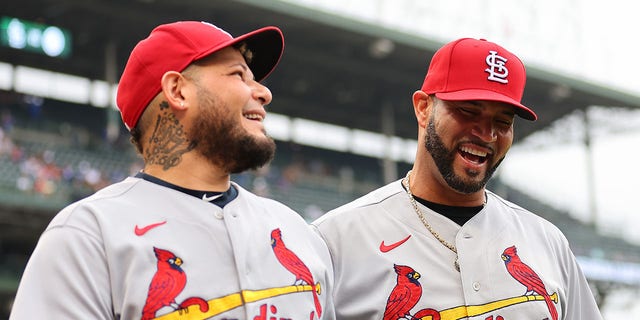 Yadier Molina #4 and Albert Pujols #5 of the St. Louis Cardinals walk off the field after a presentation commemorating their final game at Wrigley Field against the Chicago Cubs on August 25, 2022 in Chicago, Illinois.