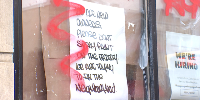 Vandalism is seen in Minneapolis after looting by rioters. The handwritten sign on the window reads, "We are new owners. Please don't spray paint on the property. We are trying to fix the neighborhood."