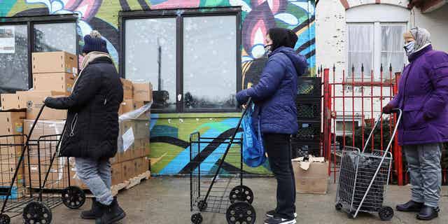 People wait in line for food at New Life Centers' food pantry in Chicago, Illinois, on March 16, 2021, as the Coronavirus exacerbated public health issues in the U.S.