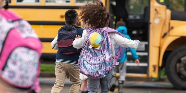 Children run toward their school bus. All too often, kids' backpacks seem like an innocent back-to-school item, suggested one doctor; yet heavy backpacks can create medical issues with youngsters' spines and necks. 
