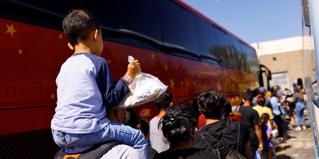 Migrants queue to board a charter bus outside the El Paso Migrant Welcome Center in El Paso, Texas. The city has sent more than 100 busloads of migrants to New York City and Chicago.