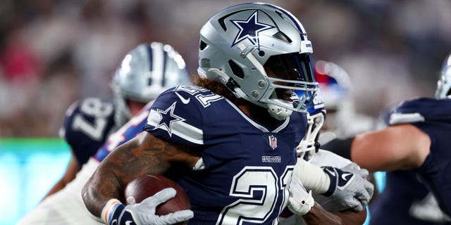 Ezekiel Elliott #21 of the Dallas Cowboys runs the ball against Nick Williams #93 of the New York Giants during the third quarter in the game at MetLife Stadium on September 26, 2022 in East Rutherford, New Jersey.