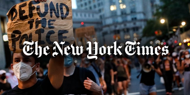 A demonstrator holds a sign that reads "Defund the police" during a protest march in support of the Black Lives Matter movement and other groups, Thursday, July 30, 2020, in New York. 