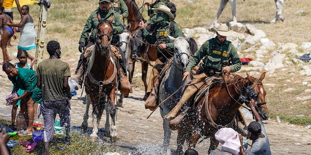 U.S. Customs and Border Protection mounted officers attempt to contain migrants as they cross the Rio Grande from Ciudad Acuña, Mexico, into Del Rio, Texas, Sunday, Sept. 19, 2021. Agents involved in the incident are expected to face unspecified discipline. 