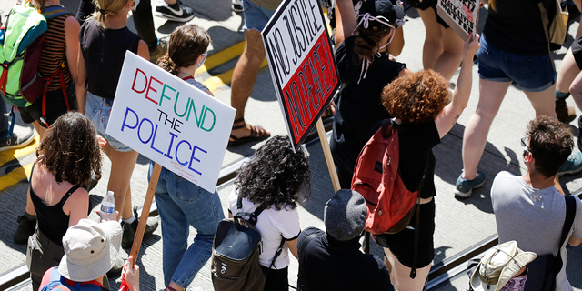 People carry signs during a "Defund the Police" march in Seattle, Washington, on Aug. 5, 2020.