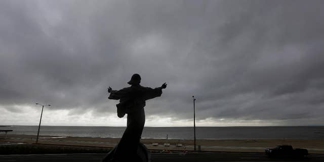 A statue of Jesus calming the sea titled "It is I" faces the bay and gulf, in Corpus Christi, Tuesday, June 16, 2015, as Tropical Storm Bill begins to make landfall.