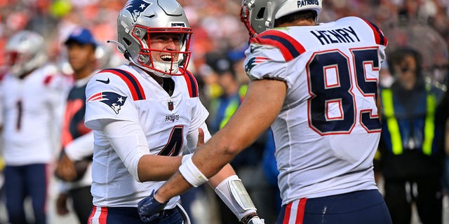 New England Patriots quarterback Bailey Zappe (4) celebrates after throwing a touchdown pass to tight end Hunter Henry (85) during the second half of an NFL football game against the Cleveland Browns, Sunday, Oct. 16, 2022, in Cleveland. 