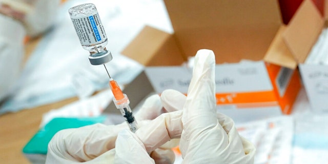 A nurse fills a syringe with the Johnson &amp; Johnson COVID-19 vaccine. 