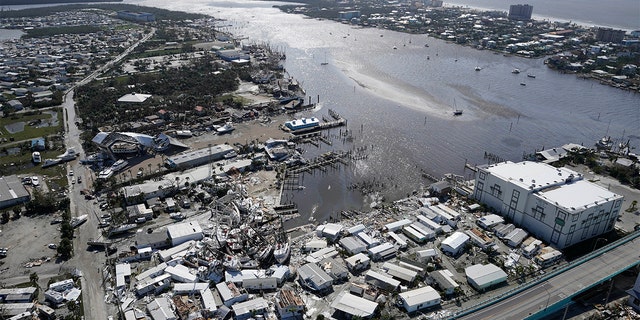 Damages boats lie on the land and water in the aftermath of Hurricane Ian, Thursday, Sept. 29, 2022, in Fort Myers, Florida. 