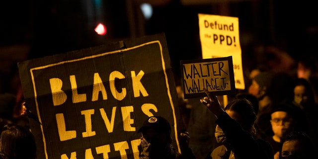 PHILADELPHIA, PA - OCTOBER 27:  Demonstrators hold placards reading "BLACK LIVES MATTER," "Walter Wallace JR." and DEFUND PPD" as they gather in protest near the location where Walter Wallace, Jr. was killed by two police officers on October 27, 2020 in Philadelphia, Pennsylvania. Protests erupted after the fatal shooting of 27-year-old Wallace Jr, who Philadelphia police officers claimed was armed with a knife. (Photo by Mark Makela/Getty Images)