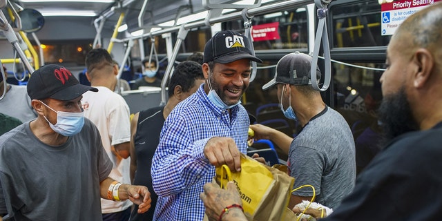 A group of migrants who arrived on a bus from Texas are given cheeseburgers as they prepare to take a CTA bus to a Salvation Army shelter on Aug. 31, 2022, in Chicago.  