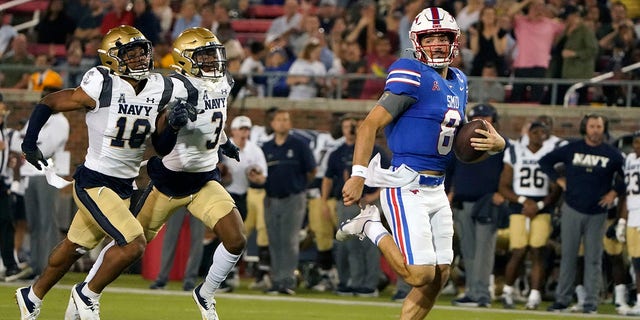SMU quarterback Tanner Mordecai (8) rushes for a touchdown against Navy defender Rayuan Lane III (18) and Elias Larry (3) during the third quarter of an NCAA college football game in Dallas, Friday, Oct. 14, 2022.