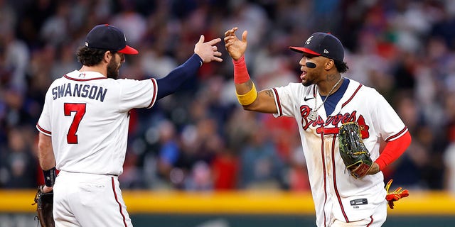 Dansby Swanson #7 and Ronald Acuna Jr. #13 of the Atlanta Braves celebrate the 4-2 victory over the New York Mets at Truist Park on October 1, 2022 in Atlanta, Georgia.