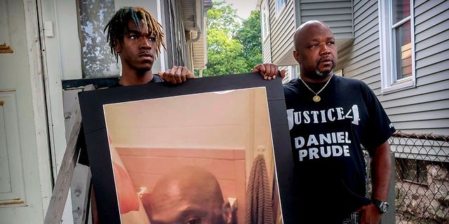 Armin Prude, left, and Joe Prude hold an enlarged photo of Daniel Prude, Sept. 3, 2020, who died following a police encounter, in Rochester, N.Y. 