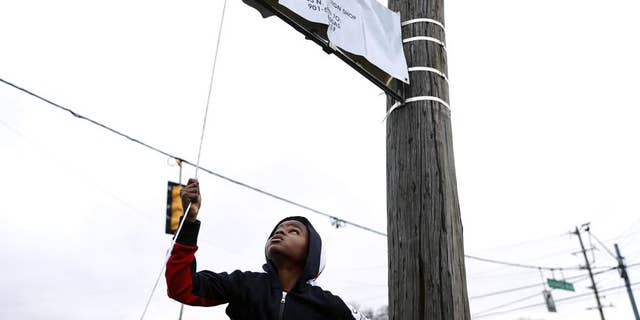 Young Dolph's son, Tre Tre, helps unveil a new street sign at a street naming ceremony honoring Young Dolph in Memphis, Tenn., Dec. 15, 2021.
