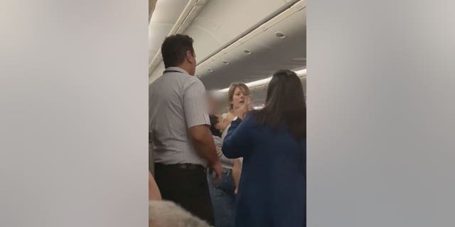 United Airlines flight attendants confront a "disruptive customer" on a flight from San Francisco to Chicago Sunday morning. 