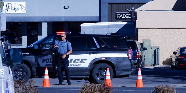 A police officer exits his car near a crime scene at a gay nightclub in Colorado Springs, Colo., Sunday, Nov. 20, 2022 where a shooting occurred late Saturday night.