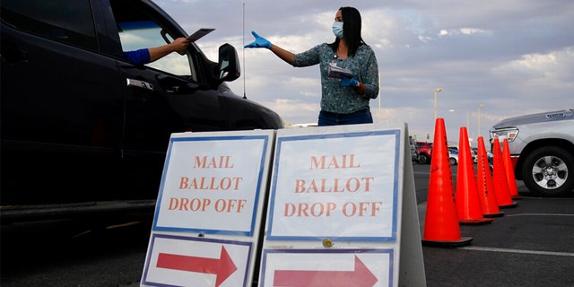 A county worker collects mail-in ballots in a drive-thru mail-in ballot drop off area at the Clark County Election Department in Las Vegas.