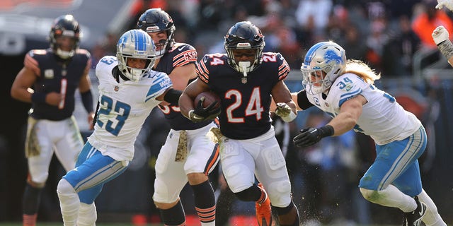 Khalil Herbert (24) of the Chicago Bears runs past Mike Hughes (23) and Alex Anzalone (34) of the Detroit Lions during the third quarter at Soldier Field Nov. 13, 2022, in Chicago.